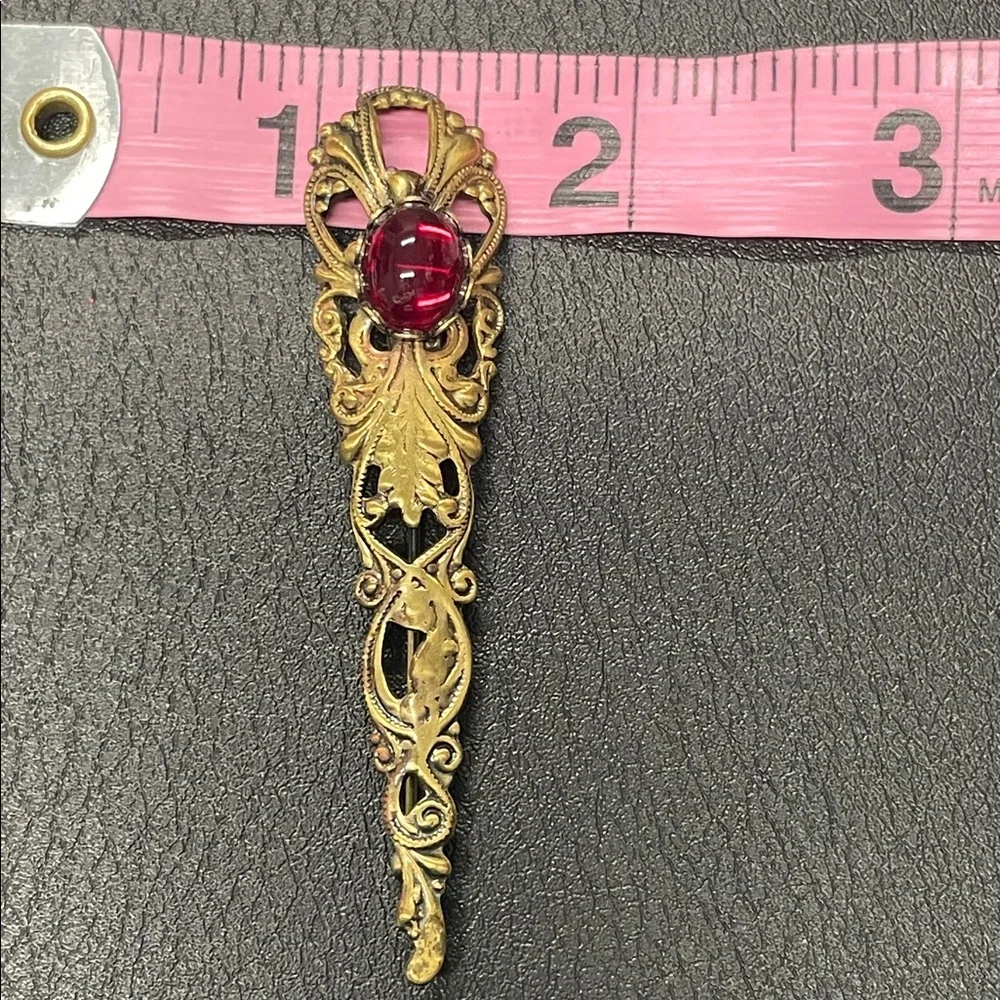 Filigree gold toned, brooch pin with red stone